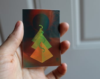 May include: A rectangular art print featuring three stylized pyramids in shades of orange and green, with a green snake-like design winding through them. The background has a dark red and green gradient with a dark circle.