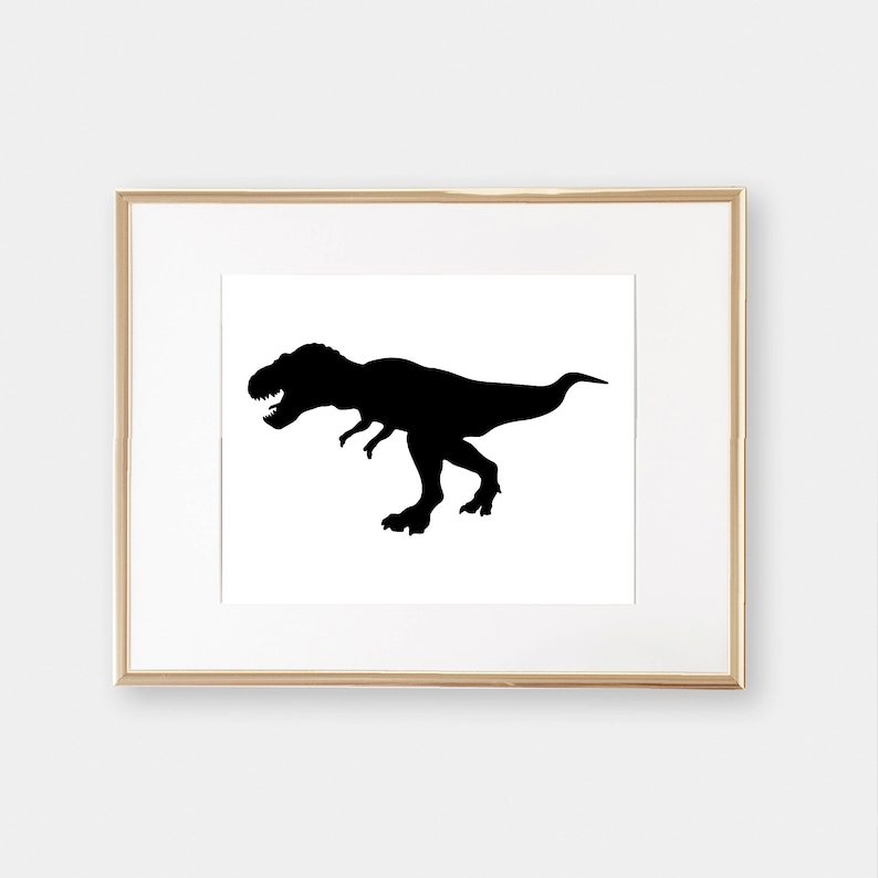 May include: A black silhouette of a Tyrannosaurus Rex dinosaur in a gold frame.