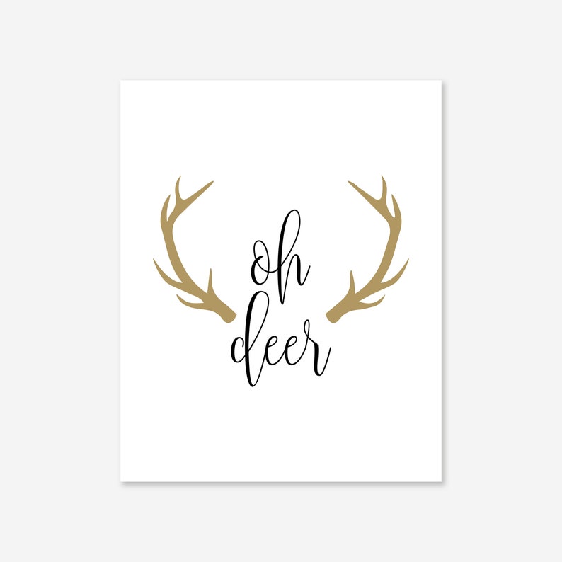 May include: A white background with a gold silhouette of a deer's antlers and the text "oh deer" in black cursive font.