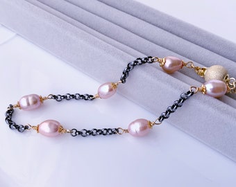 Puede incluir: Collar con perlas ovaladas rosas intercaladas con eslabones de cadena gris oscuro. Las perlas están unidas con alambre dorado. El cierre incluye una cuenta dorada texturizada. Longitud: aprox. 45 cm.