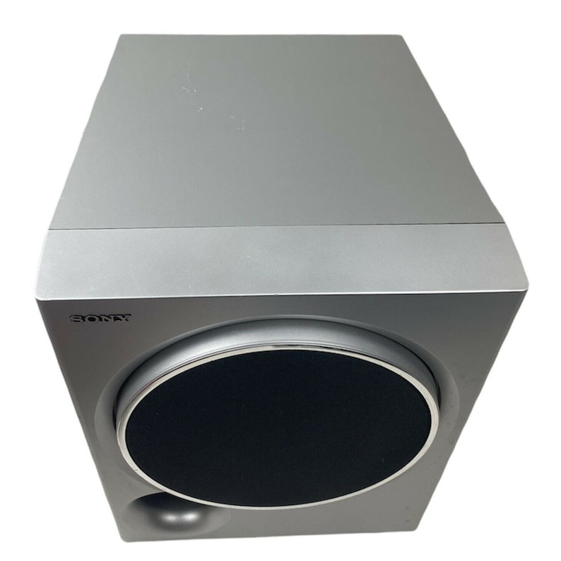 Pu&ograve; includere: Un subwoofer Sony argentato con una griglia per altoparlanti nera. Il subwoofer ha una parte anteriore arrotondata e una forma rettangolare.