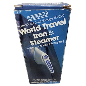 May include: A blue box with white text that reads "OSROW International Dual Voltage 110/220 World Travel Iron & Steamer (With Continental Adapter)". The box shows a white and blue travel iron and steamer. The text at the bottom of the box reads "The only Iron or Steamer that works both Horizontally & Vertically!"