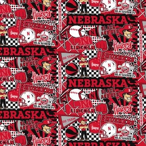 May include: A repeating pattern featuring Nebraska Cornhuskers imagery. The design includes football helmets, footballs, the word "Nebraska," and the team's mascot in red, black, and white. The words "Blackshirts" and "Lincoln" are also present.
