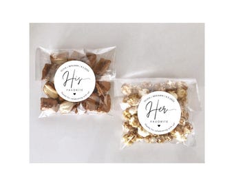 May include: Two clear cellophane bags filled with treats. One bag contains chocolate-covered candies, and the other contains caramel popcorn. Each bag has a white circular sticker with the words "His Favorite" and "Her Favorite" in elegant script.
