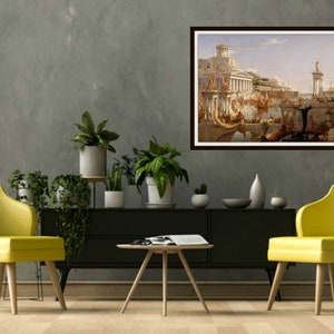 May include: A framed painting of a city scene with a large building in the center and many people in the foreground. The painting is in a brown frame and is hanging on a gray wall.