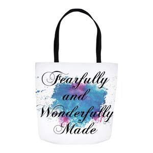 May include: White canvas tote bag with black handles and a watercolor design of blue and pink splatters. The text "Fearfully and Wonderfully Made" is written in black cursive script.