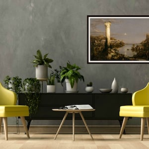 May include: A framed painting of a landscape with a tall tower in the center. The tower is lit by a bright light, and the rest of the landscape is bathed in a soft, golden light. The painting is set against a gray wall, and there are two yellow chairs and a coffee table in the foreground.