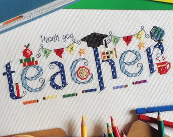 Op de afbeelding: Borduurwerk met kruissteek van het woord "leraar" op een blauwe en witte achtergrond. Het woord is versierd met kleurrijke schoolthema-elementen, waaronder een afstudeerhoed, een aardbol, potloden en een rode appel.