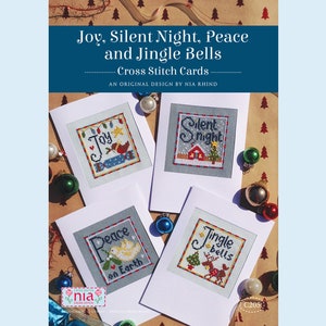 May include: Four cross stitch cards with Christmas themes. The cards feature the words "Joy", "Silent Night", "Peace on Earth", and "Jingle Bells". Each card has a different design with a festive image.