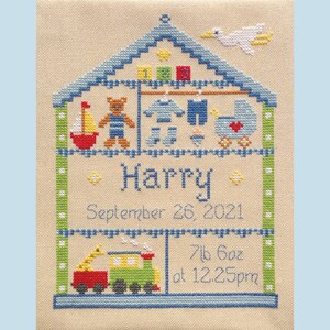 Puede incluir: Un dise&ntilde;o de punto de cruz de una casa azul con un p&aacute;jaro blanco en el techo. La casa est&aacute; llena de art&iacute;culos para beb&eacute;s, incluyendo un osito de peluche, un velero, un cochecito y un tren. El nombre "Harry" est&aacute; bordado debajo de la casa, junto con la fecha "26 de septiembre de 2021" y el peso y la hora de nacimiento: "7lb 6oz a las 12:25pm".