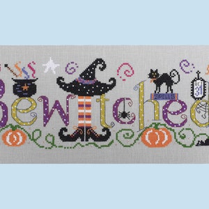 May include: Cross-stitch embroidery design featuring the word "Bewitched" with a witch, a black cat, a cauldron, pumpkins, and a broom. The design is on a gray background with white polka dots.