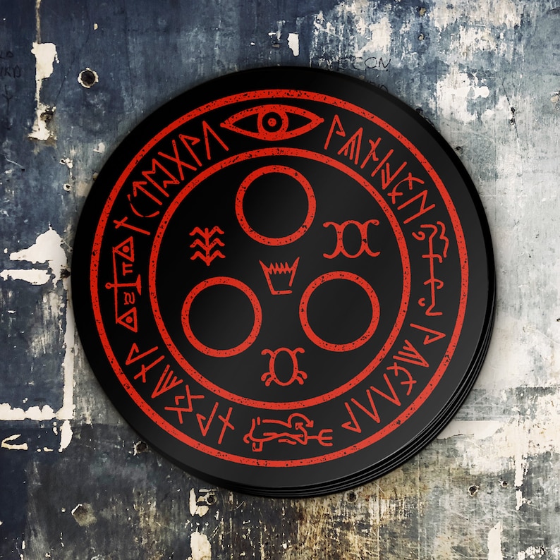 Puede incluir: Un s&iacute;mbolo circular negro y rojo con un ojo estilizado, una corona y otros s&iacute;mbolos. El s&iacute;mbolo est&aacute; rodeado por un anillo de texto en una fuente estilizada.