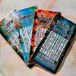 May include: Four colorful cards with a savings challenge theme. Each card features a different season: Spring, Summer, Autumn, and Winter. The cards have a grid with numbers 5, 10, and 20. The Winter card has the text "Total Saved: $250".
