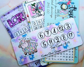May include: A collection of colorful budget cards with floral and scripture-themed designs. One card features a sheep illustration and the text "The Lord is my Shepherd." Other cards include the words "LOVE," "True Story," and savings trackers.