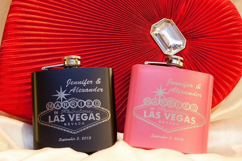 以下が含まれることがあります： 「Jennifer & Alexander Married in Fabulous Las Vegas Nevada September 5, 2015」と刻まれた、黒とピンクの2つのパーソナライズされたヒップフラスコ