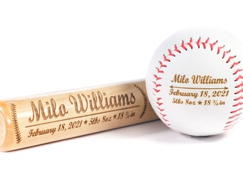 May include: A wooden baseball bat and a white baseball with red stitching are engraved with the name "Milo Williams" and the date "February 18, 2021". The bat also includes the baby's weight and length: "5lbs 8oz * 18 3/4 in".