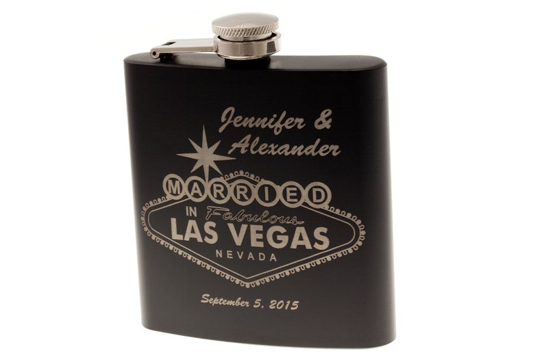 以下が含まれることがあります： 銀色の蓋が付いた黒いステンレス製のフラスコで、"Jennifer & Alexander Married in Fabulous Las Vegas Nevada September 5, 2015"という文字が刻まれています。