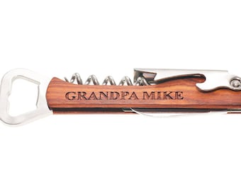 May include: A wooden bottle opener with a corkscrew and a bottle cap opener. The handle is engraved with the text "GRANDPA MIKE".