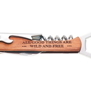 May include: A wooden handled multi-tool with a bottle opener, corkscrew, and a small knife. The handle is engraved with the text "All good things are *** wild and free ***".