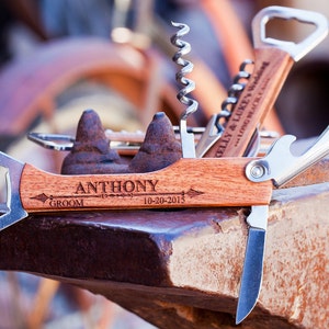 May include: A wooden multi-tool with a bottle opener, corkscrew, and knife. The tool is engraved with the name "ANTHONY" and the date "10-20-2015".