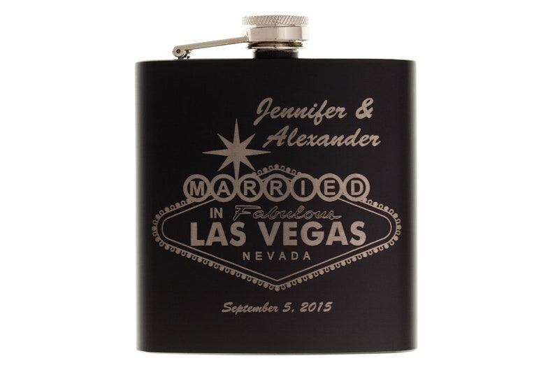 以下が含まれることがあります： 銀色の蓋が付いた黒い金属製のフラスコで、"Jennifer & Alexander Married in Fabulous Las Vegas Nevada September 5, 2015"という文字が刻まれています。