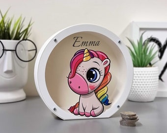 May include: White wooden piggy bank with a round opening. The front features a colorful cartoon unicorn with a rainbow mane and tail. The name "Emma" is written above the unicorn.