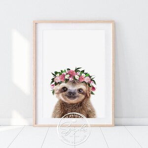 Könnte beinhalten: Ein braunes Faultier, das eine rosafarbene Blumenkrone trägt. Das Faultier schaut direkt in die Kamera und lächelt. Der Hintergrund ist weiß.