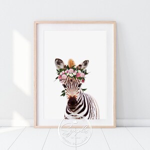 Könnte beinhalten: Ein schwarz-weißes Zebra mit einer rosa-weißen Blumenkrone. Das Zebra schaut in die Kamera. Der Hintergrund ist weiß.