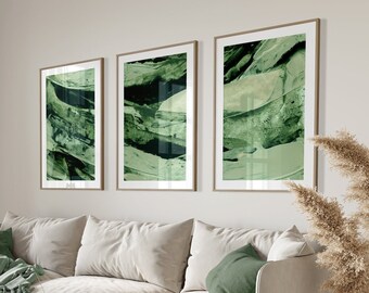 May include: A light beige sofa with green throw pillows and a green throw blanket. The sofa is in a living room with a green curtain, a wooden floor, and three abstract green paintings on the wall.