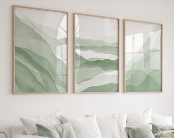May include: A white sofa with green pillows and a throw blanket, a wooden coffee table with a vase of pink flowers, and three framed abstract watercolor paintings with green and white hues on a white wall.