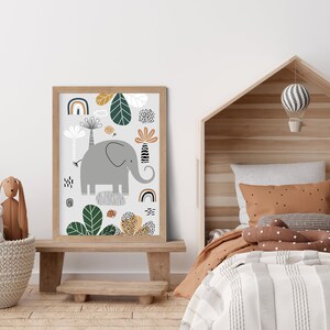 May include: A framed print with a whimsical illustration of an elephant standing on a rock surrounded by green leaves and colorful geometric shapes. The print is in a light wood frame and is hanging on a white wall.