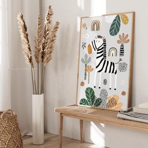 May include: A white and black zebra illustration with a rainbow and green foliage on a light gray background. The illustration is framed in a light wood frame.