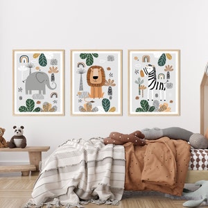 May include: Three framed illustrations of animals in a jungle setting. The illustrations are in a modern style with bold colors and simple shapes. The first illustration features an elephant, the second a lion, and the third a zebra.