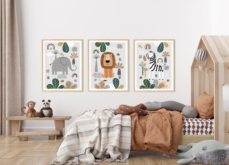 May include: Three framed illustrations of animals in a jungle setting. The illustrations are in a modern style with bold colors and simple shapes. The first illustration features an elephant, the second a lion, and the third a zebra.