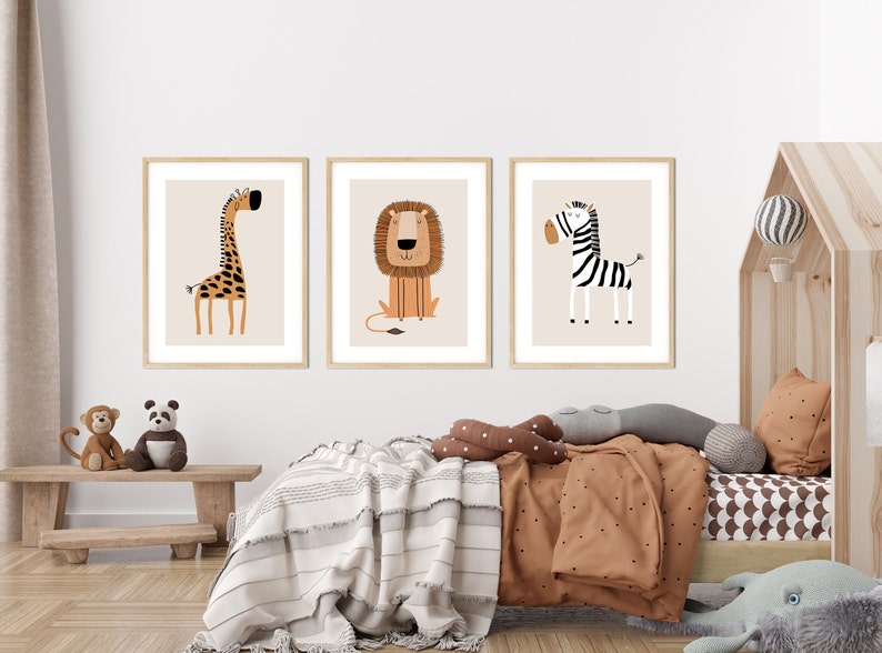 May include: Three framed illustrations of animals in a nursery setting. The illustrations are of a giraffe, a lion, and a zebra. The illustrations are in a minimalist style with simple lines and bright colors.