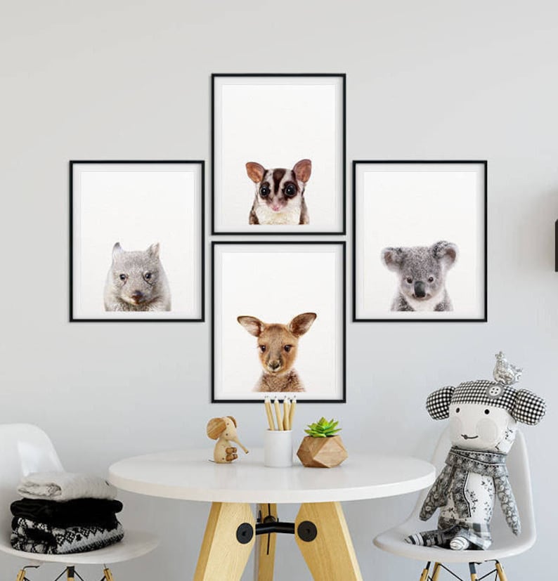 Puede incluir: Cuatro impresiones enmarcadas en negro de animales australianos, incluyendo un koala, un wombat, un planeador de az&uacute;car y un canguro. Las impresiones est&aacute;n colgadas en una pared blanca sobre una mesa blanca con una silla de madera y un animal de peluche.