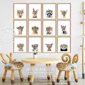 May include: A set of 12 printable nursery art prints featuring various animals wearing flower crowns. The prints are in a grid of 4 rows and 3 columns, with each print framed in a light brown frame. The animals include a fox, rabbit, raccoon, deer, giraffe, lion, zebra, tiger, koala, kangaroo, and panda. The prints are perfect for a nursery or child's room.