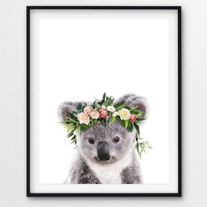 May include: A cute koala wearing a flower crown with pink, white, and yellow flowers. The koala is looking at the camera with a sweet expression.