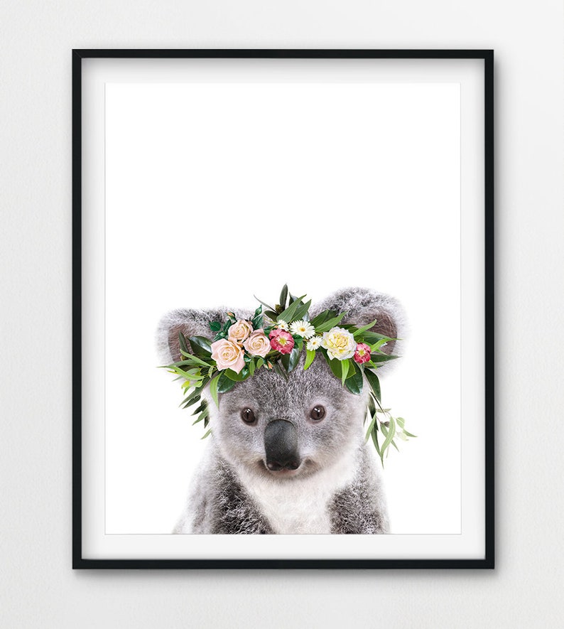 May include: A cute koala wearing a flower crown with pink, white, and yellow flowers. The koala is looking at the camera with a sweet expression.
