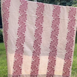 May include: A rectangular fabric panel featuring a light beige base color with vertical stripes of a deep rose-colored floral and vine pattern. The textile displays a repeating botanical motif consisting of stylized leaves and dots arranged in columns.