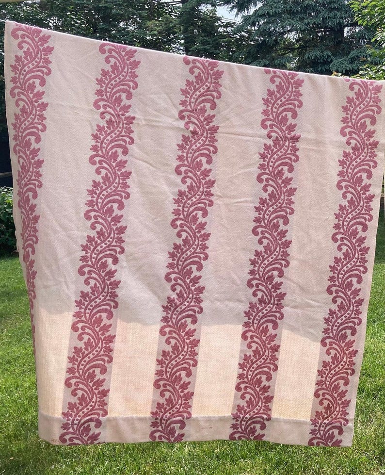 May include: A rectangular fabric panel featuring a light beige base color with vertical stripes of a deep rose-colored floral and vine pattern. The textile displays a repeating botanical motif consisting of stylized leaves and dots arranged in columns.