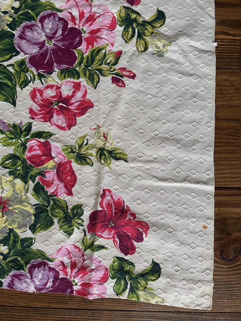 K&ouml;nnte beinhalten: Ein floraler Stoff mit einem sich wiederholenden Rautenmuster. Er zeigt gro&szlig;e, farbenfrohe Blumen in Rot, Rosa und Lila mit gr&uuml;nen Bl&auml;ttern. Die Blumen sind in einem Kaskaden-Design angeordnet und schaffen einen ansprechenden Textil.