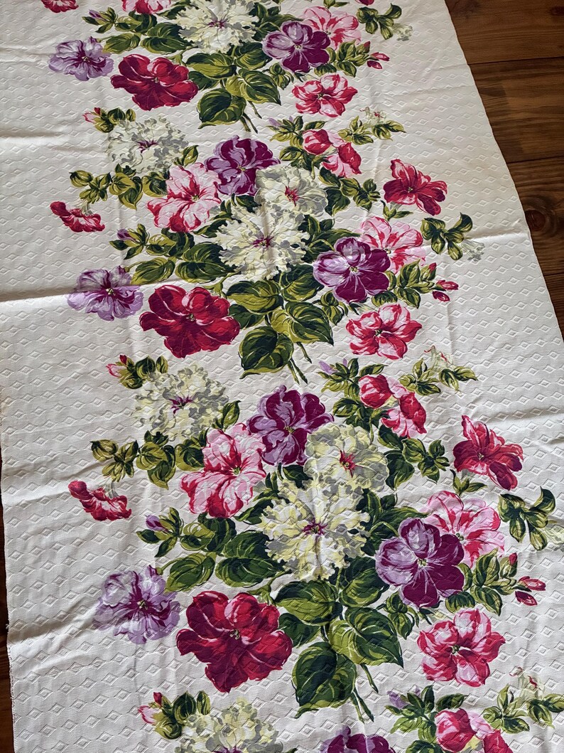K&ouml;nnte beinhalten: Cremefarbener Stoff mit Rautenmuster, verziert mit einem floralen Design. Die Blumen sind in Rot, Rosa, Lila und Wei&szlig; gehalten, mit gr&uuml;nen Bl&auml;ttern. Geeignet f&uuml;r Heimtextilien.