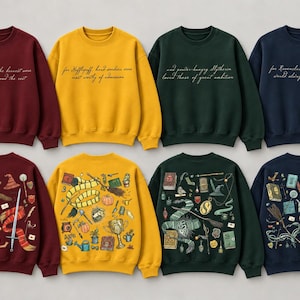 May include: A collection of eight crewneck sweatshirts in maroon, yellow, dark green, and navy blue. The front of each features cursive text, while the back displays detailed, colorful illustrations of magical items, books, and house-themed accessories.