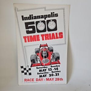 May include: Vintage Indianapolis 500 Time Trials poster. The poster features the text "Indianapolis 500 TIME TRIALS" in black and red. A red race car is depicted below the text. Dates for the event are listed in red and black.