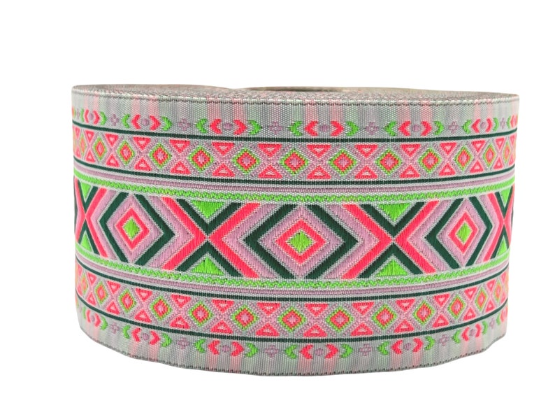 May include: A roll of pink, green, and black patterned trim with a geometric design. The trim is woven with a silver thread.