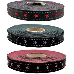 May include: Three spools of black ribbon with different coloured stars. The top spool has red stars, the middle spool has purple stars, and the bottom spool has silver stars.