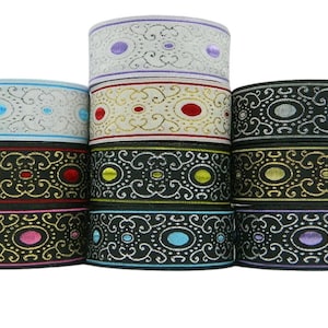 May include: Assortment of decorative trim with a black background and gold, silver, red, blue, and purple accents. The trim features a repeating pattern of swirls and circles.