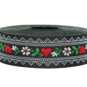 Könnte beinhalten: Eine Rolle schwarzes Band mit einem weißen und grünen Blumenmuster und roten Herzen. Das Band ist mit einem sich wiederholenden Muster aus Blumen, Blättern und Herzen gewebt.