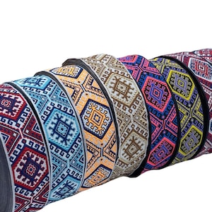 Può includere: Una collezione di rotoli di nastro con motivi colorati e disegni geometrici. Il nastro è tessuto con una varietà di colori, tra cui rosso, blu, giallo e verde.